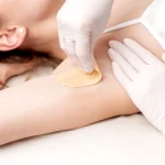 cosmetologist-applying-wax-paste-armpit