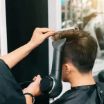 hands-unrecognizable-hairdresser-giving-male-customer-blowdry-with-hairdryer-comb
